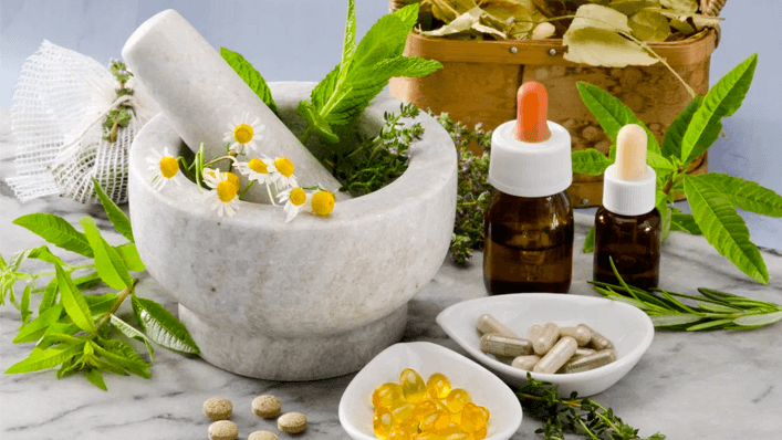 Pilão com flores e ervas para a fabricação de cápsulas e gotas de homeopatia