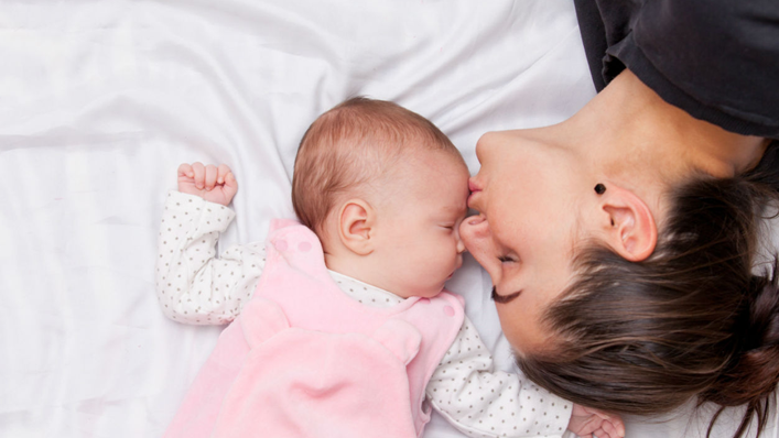 mãe beijando a testa de um bebê - olfato
